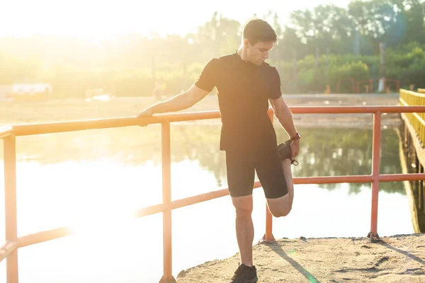 Bacağını bir çalışma daha önce germe fitness adam açık havada. — Stok fotoğraf