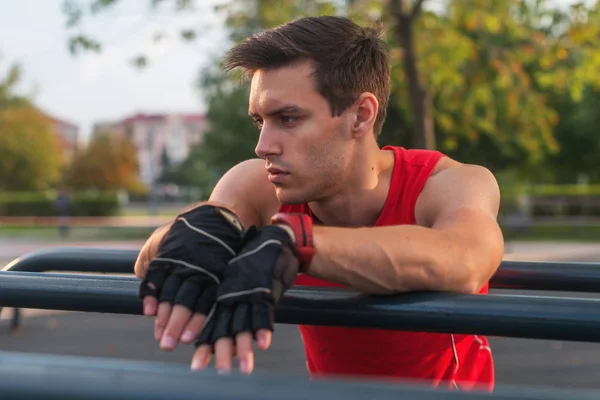 Sportieve jongeman nemen van een pauze tijdens het trainen buiten. — Stockfoto