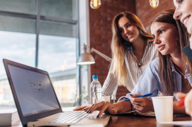 Üç kadın kolej öğrencileri birlikte bilgi arama dizüstü kullanarak internet'te sörf