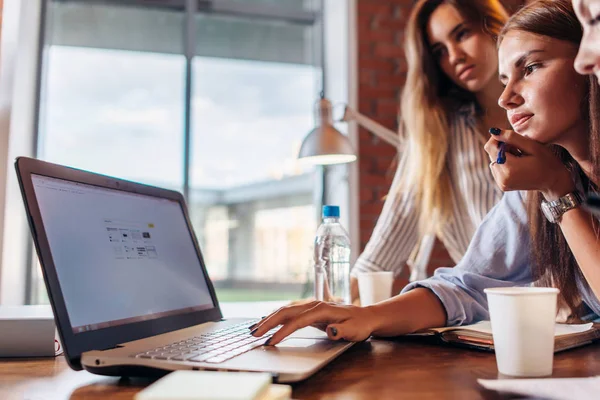 Ofis çalışanları birlikte bir dizüstü bilgisayar kullanarak Grup