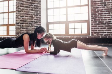 Anne ve kızı yunus tahta ayakta poz, phalankasana, fitness Center'da yoga seansı sırasında