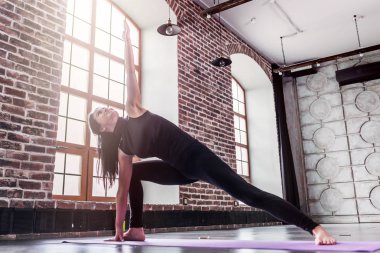 Sportif kadın pratik yoga üçgen poz, mat trikonasana yapıyor