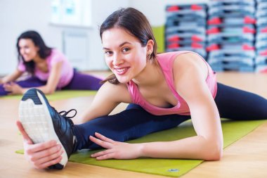 Kadın onun kalça kaçıran kas ve bağ çalışma çapraz bölünmüş egzersiz yapmak. Uygun kadın atlet spor salonunda bölmelerini germe.