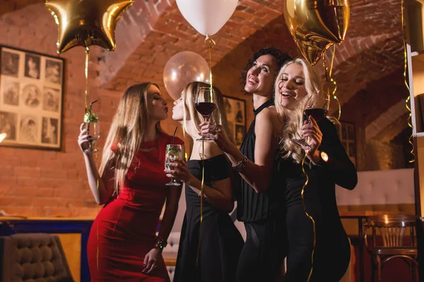 Щасливі привабливі молоді жінки, що проводять вечірку на день народження, сміються, танцюють, співають, насолоджуються ніччю в стильному ресторані — стокове фото