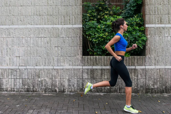Zobrazení profilu sportovní mladé ženy cvičit venku. Fitness holka běžící na chodníku. — Stock fotografie