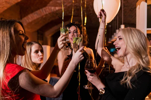 Feliz atractivas mujeres jóvenes que tienen fiesta de cumpleaños riendo, bailando, cantando, disfrutando de la noche en un restaurante elegante —  Fotos de Stock