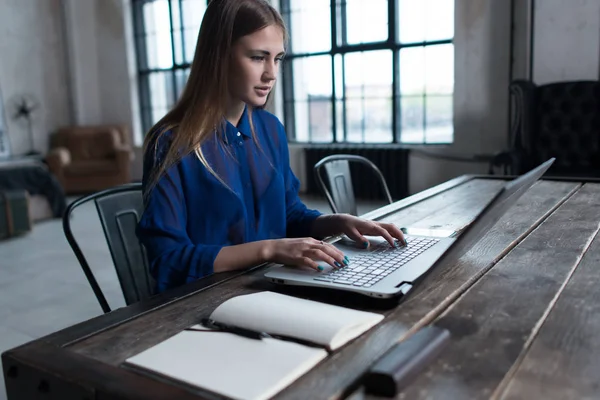 Женщина с руками на клавиатуре ноутбука. Дизайнер сидит за рабочим столом с ноутбуком и компьютером на нем . — стоковое фото