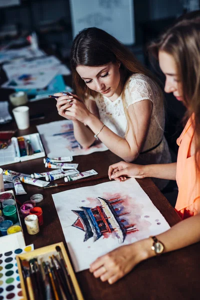 Dvě mladé ženy účast aquarelle Malování tříd pro dospělé na umělecké škole. Dívka ukazuje její kresby příteli. — Stock fotografie