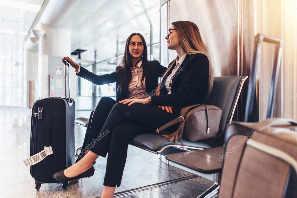 Two business ladies waiting for the flight in airport international terminal