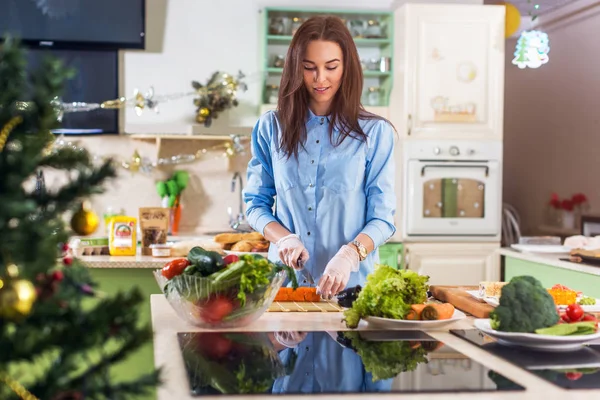 Jovem senhora caucasiana cozinhar Ano Novo ou refeição de Natal na cozinha decorada em casa — Fotografia de Stock