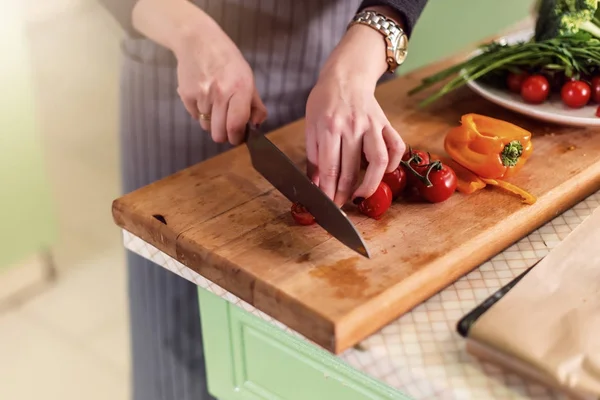 Close-up beeld van jonge vrouw s handen snijden groenten aan boord voor pizza volgens receptenboek — Stockfoto