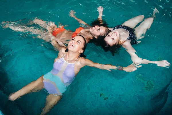 Divertidas mujeres adolescentes jugando en la piscina riendo y disfrutando de sus fines de semana —  Fotos de Stock