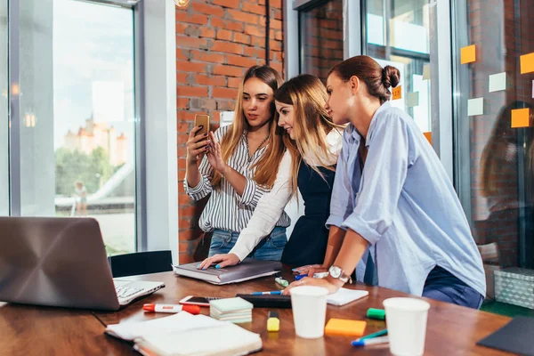 Vrouwelijke student tonen video op haar smartphone aan vrienden thuis examen voorbereiden — Stockfoto