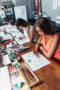 Yeni proje çizimleri ile kalemler çizim üzerinde iki kadın tasarımcılar