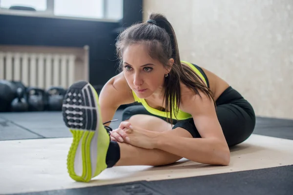 Jonge fit vrouw doen zittend naar voren vouwen oefening, sportieve vrouw die zich uitstrekt — Stockfoto
