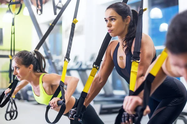 Γυναίκα αθλητή που κάνει push ups με trx ιμάντες γυμναστικής στο γυμναστήριο έννοια προπόνηση υγιούς αθλητισμού. — Φωτογραφία Αρχείου