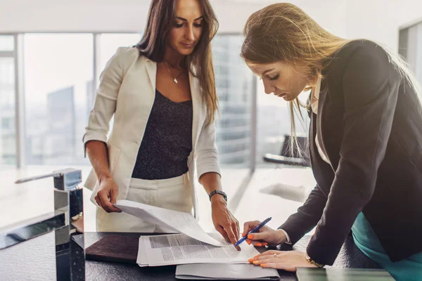 Twee vrouwen ondertekenen een contract staan in moderne appartement — Stockfoto