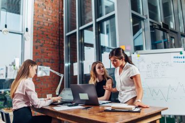 Kadın start-up takım yaratıcı studio istimal bilgisayar masasında oturan yeni proje hakkında sohbet