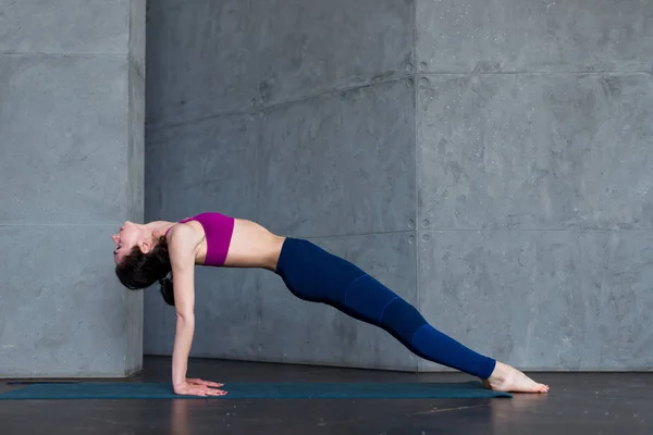Jolie femme mince en soutien-gorge de sport et leggings faire du yoga vers le haut face à la pose de planche, purvottanasana, travailler à l'intérieur — Photo