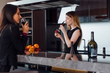 İki arkadaşları işten sonra evde rahatlatıcı şarap içme, meyve yeme, mutfakta dedikodu