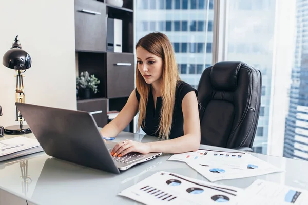 금융 데이터는 회사의 통계를 공부 하 고 노트북에서 일 하는 젊은 여자 — 스톡 사진