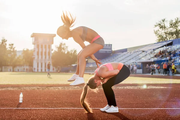 Fit mulheres no estádio jogando sapo salto . — Fotografia de Stock