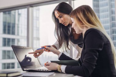 Genç kadın sırasında dizüstü bilgisayar ekranında işaret bilgileri açıklayan öğrenci yardımcı sınıf ders