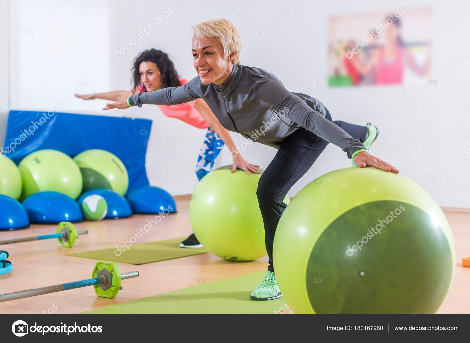 Fit Caucasian women doing crane exercise standing on one leg with their