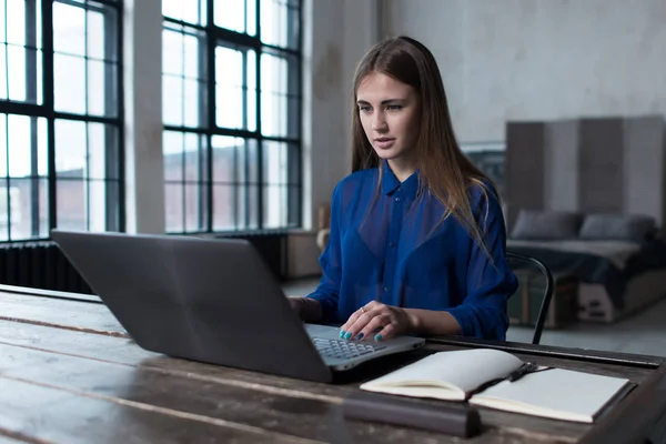 Kobieta z jej ręce na klawiaturze laptopa. Projektanta siedzi worktable z Notatnik i komputer na to. — Zdjęcie stockowe