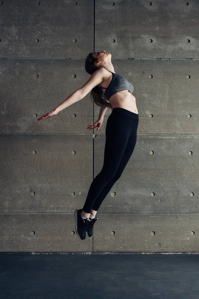 Спортивна молода жінка робить стрибок вигину спини — стокове фото