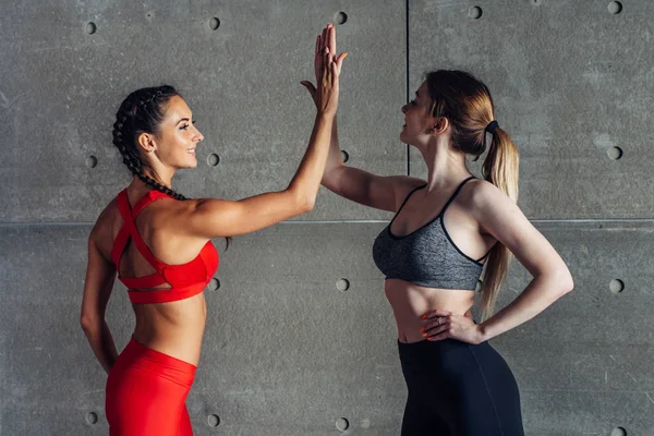 Happy fit jonge vrouw geven hoge vijf aan vriend na training. — Stockfoto