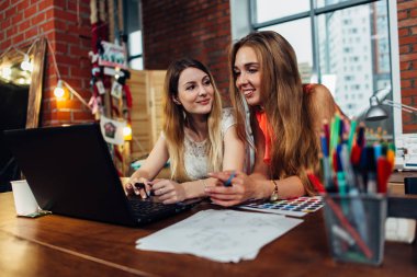 İki kadın blogcular yeni fikirler ile şık iç mekanlara evde bilgisayar başında oturan tartışırken dostça sohbet