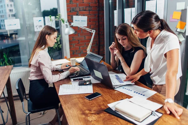 Equipo de negocios trabajando juntos estudiando gráficos y diagramas usando el portátil en la oficina moderna — Foto de Stock