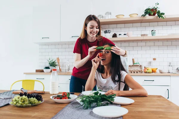 Dziewczyny, wygłupiać się w kuchni, grając z warzywami. — Zdjęcie stockowe