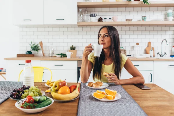 Jeune femme buvant du café à la maison le matin . — Photo