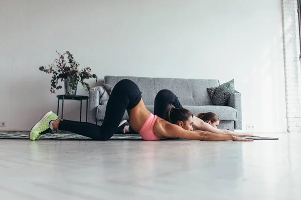 Ajustar a las mujeres haciendo ejercicio en casa realizando backbend —  Fotos de Stock
