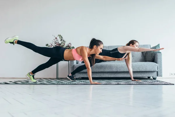 Fitte vrouwen doen een hand één been plank oefening workout thuis. — Stockfoto