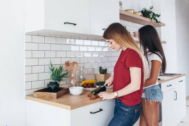 Genç kadın mutfakta yiyecek salata öğle yemeği için hazırlanıyor