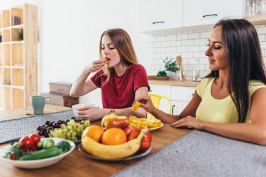 Söz ve yemek oturan iki genç kadın arkadaşlar masa.