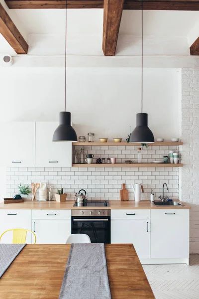 Moderno interior de luz nueva de cocina con muebles blancos y mesa de comedor — Foto de Stock