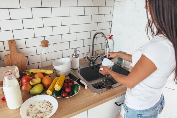 Hausarbeit. junge Frau spült Geschirr in Küche. — Stockfoto