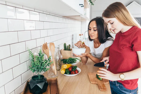 Twee vrouwen in de keuken bereiden salade. — Stockfoto