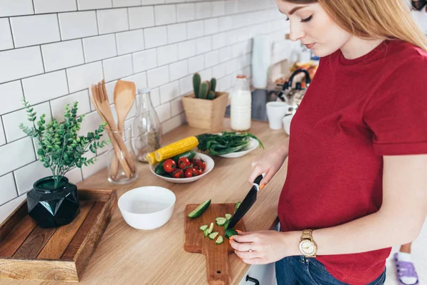 Femeie tânără care pregătește salată de legume în bucătărie . — Fotografie, imagine de stoc