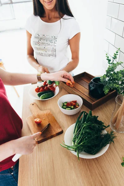 Duas meninas amigas preparando o jantar na cozinha salada de cozinha . — Fotografia de Stock