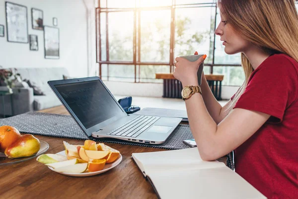 Kvinna som arbetar med laptop äter frukost dricka kaffe — Stockfoto