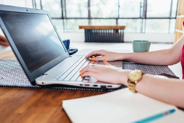 Jonge vrouw die werkt met laptop in de keuken thuis. — Stockfoto