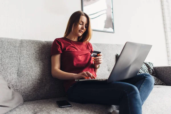 Mulher fazendo compras on-line com laptop e cartão de crédito em casa — Fotografia de Stock