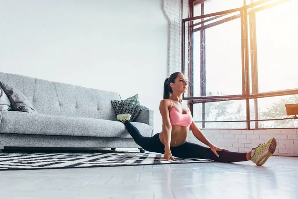 Uygun kadının evde esneklik, germe, fitness egzersiz split yapması — Stok fotoğraf