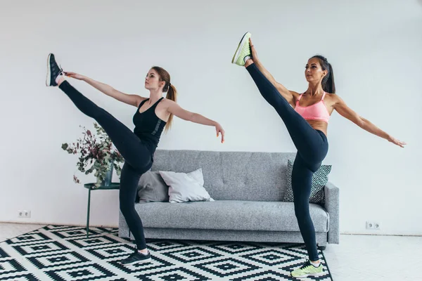 Passar kvinna stretching benen värmer upp träning hemma — Stockfoto