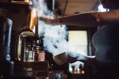 Kadın barista kahve yapma makinesi süt kafede Buhar kullanarak yakın çekim görüntüsü